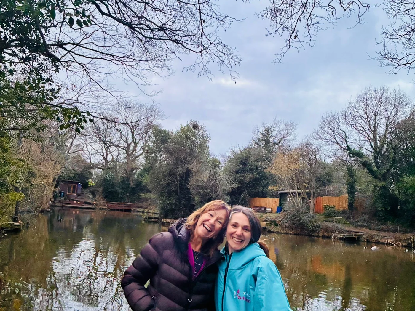 Friends beside the tree-lined water at Botts Pool